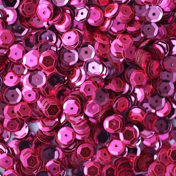 Pink pailletter 6 mm, 500 stk., skinnende runde palietter spredt foran en skål.