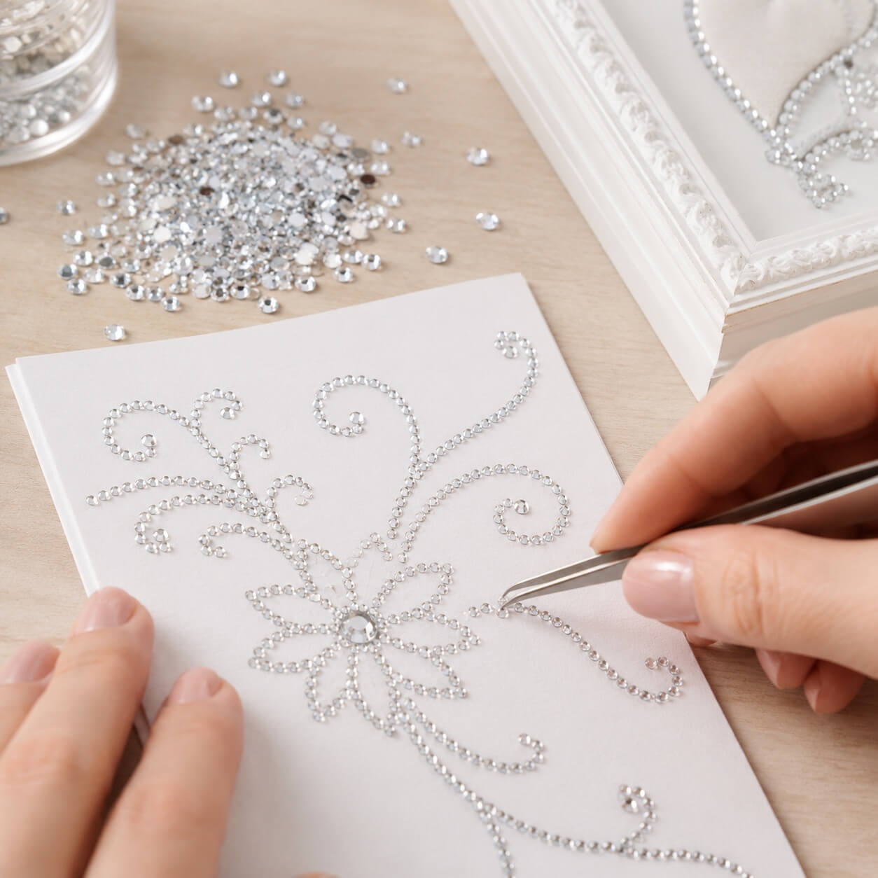 Brugsbillede af klare 2 mm flatback rhinsten, der bruges til dekoration af håndlavet kort med pincet til scrapbooking, DIY og kortfremstilling.