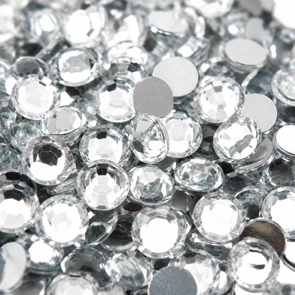 Close-up af klare 2 mm flatback rhinsten med facetslebet overflade og flad bagside til scrapbooking, DIY, kortfremstilling og dekoration.