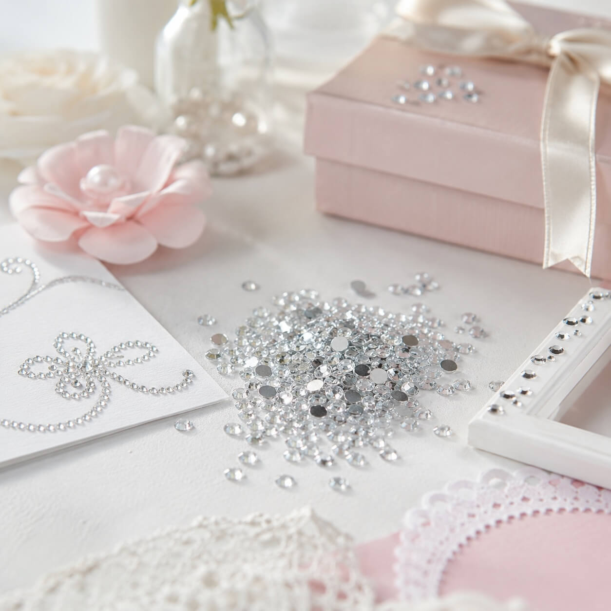 Stemningsbillede med klare 2 mm flatback rhinsten brugt til kreative hobbyprojekter, kortfremstilling, scrapbooking og elegant dekoration.