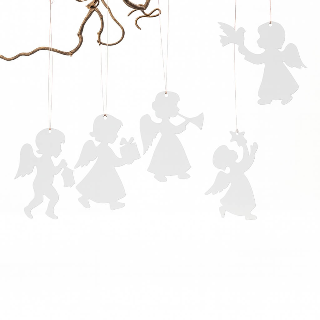 Hvide kartonengle på 15 cm hænger fra en gren, omgivet af julepynt med lanterne, gran og røde kugler.