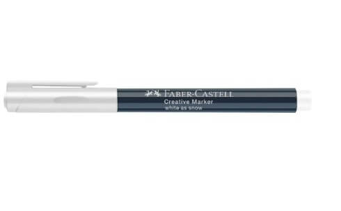 Faber-Castell Creative Marker White as Snow lagt ved kreative korkbordskånere dekoreret med hvid blæk og en latte i baggrunden.